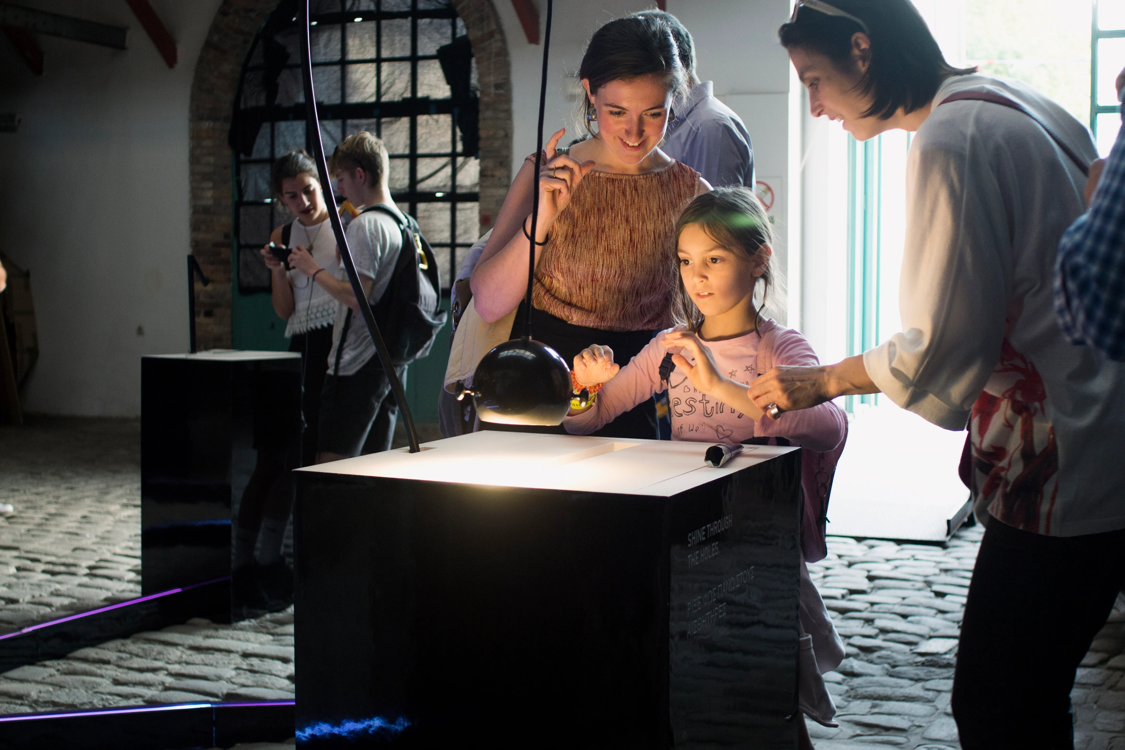 A child and parent play with the Lightefface instrument of Cave of Sounds during its exhibition at Athens Science Festival in 2018. Photo by Anastasia Alekseeva.