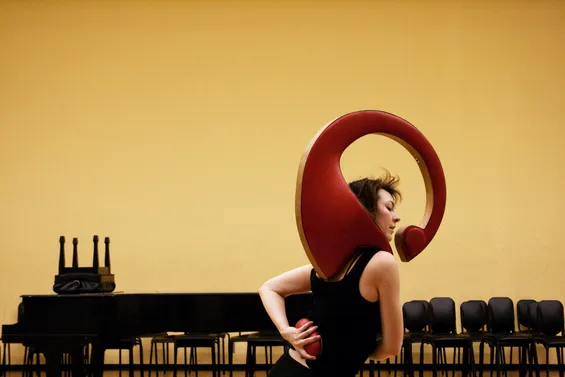 Photo of dancer Nicole Johnson performing with the Serendiptichord, a wearable instrument in red leather made by Di Mainstone and Tim Murray-Browne.