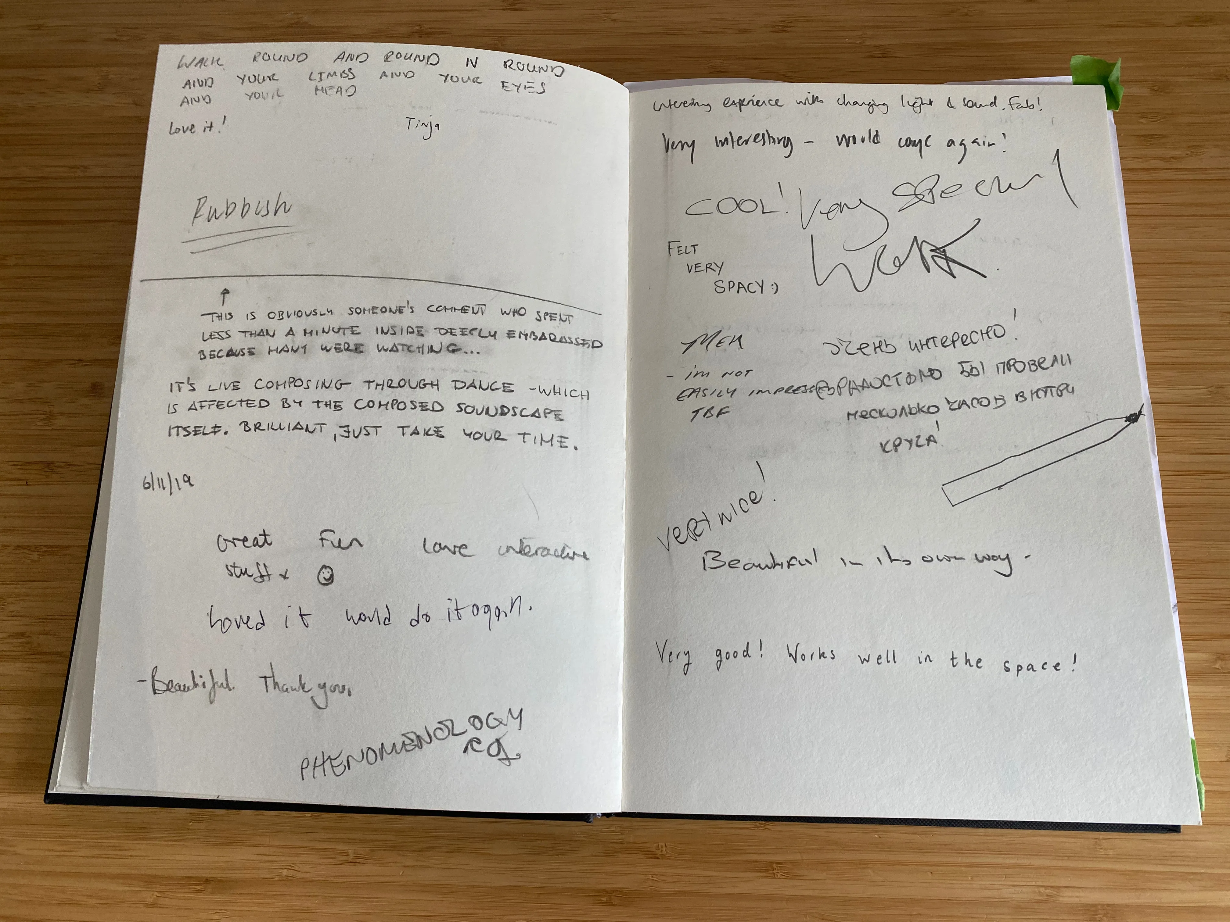 Photo of a comment book from an exhibition with various long and short comments written in different writing styles.