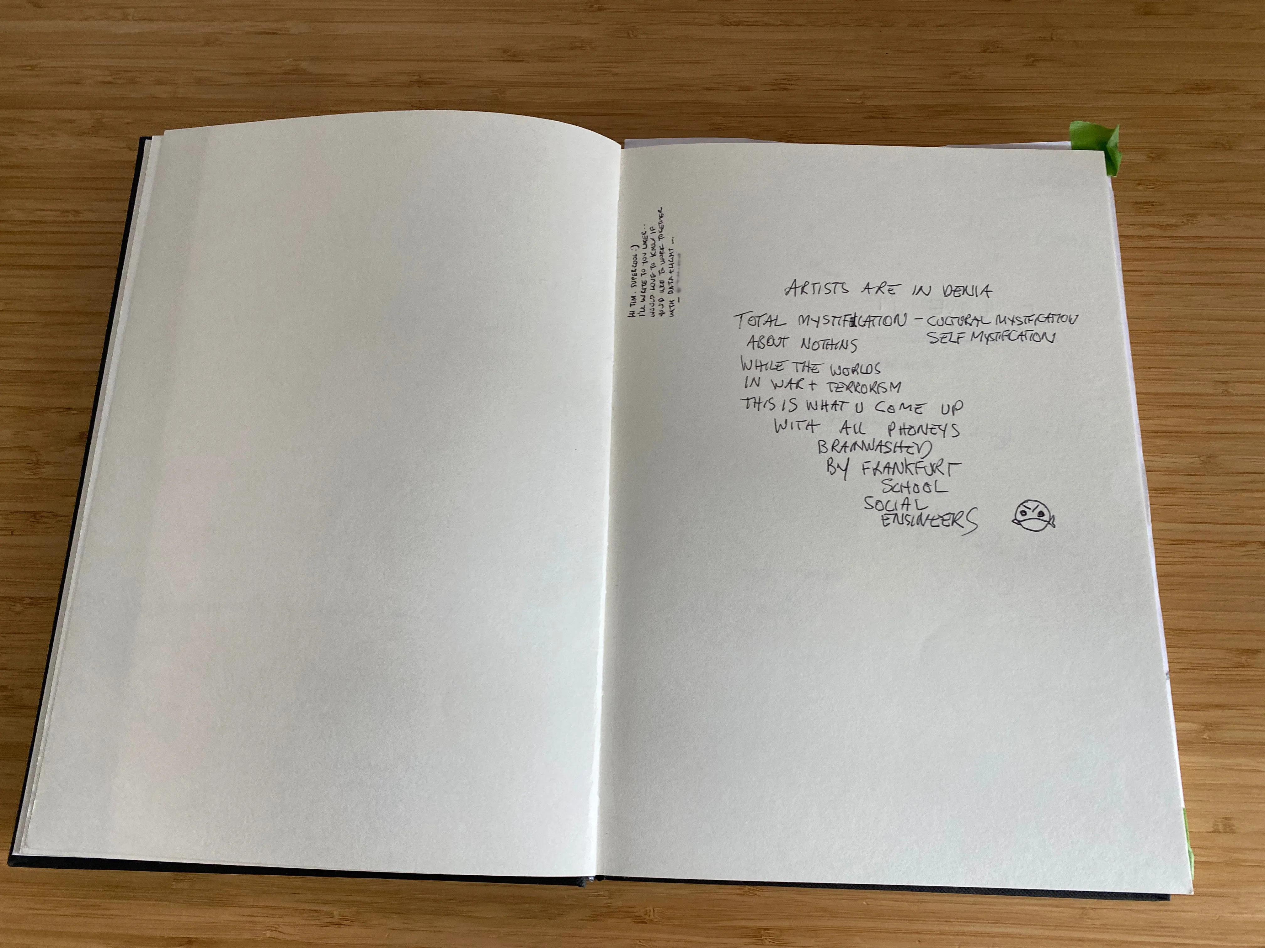 Photo of a comment book from an exhibition with mostly white space and a dominant negative comment that begins "ARTISTS ARE IN DENIA TOTAL MYSTIFICATIOn - CULTURE MYSTIFCATION SELF MYSTIFICATION ABOUT NOTHING ...".
