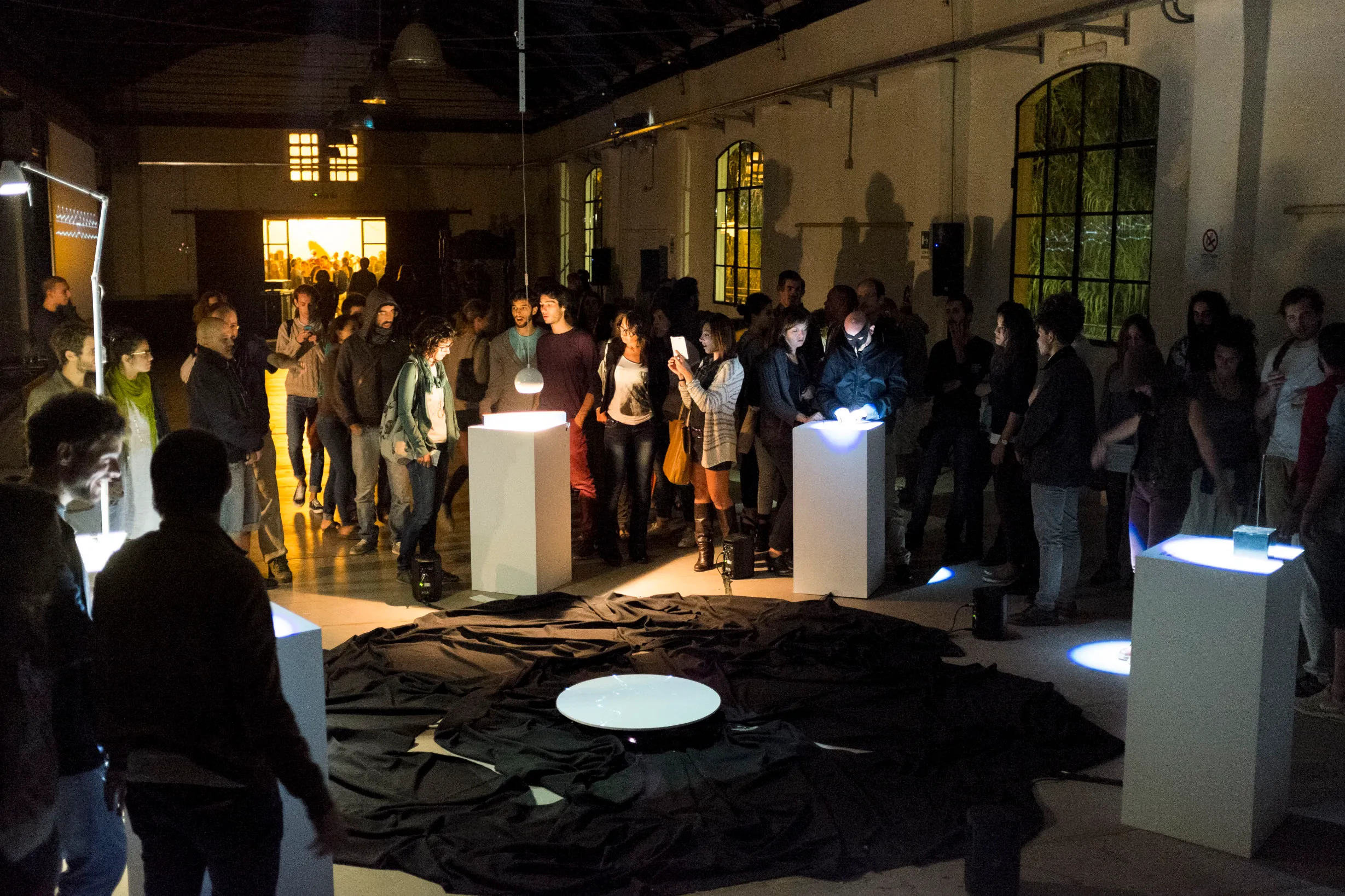 Cave of Sounds exhibited at 90dB Festival of Sonic Arts, Rome 2014. Many people crowd around the circular array of instruments. Photo: Tim Murray-Browne