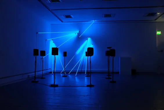 Post-Truth and Beauty, an interactive installation by Tim Murray-Browne and Aphra Shemza formed of addressable LED rods rigged to the wall and an ambisonic ring of speakers. This photo shows the work exhibited at Sonica Festival in Glasgow, 2019.