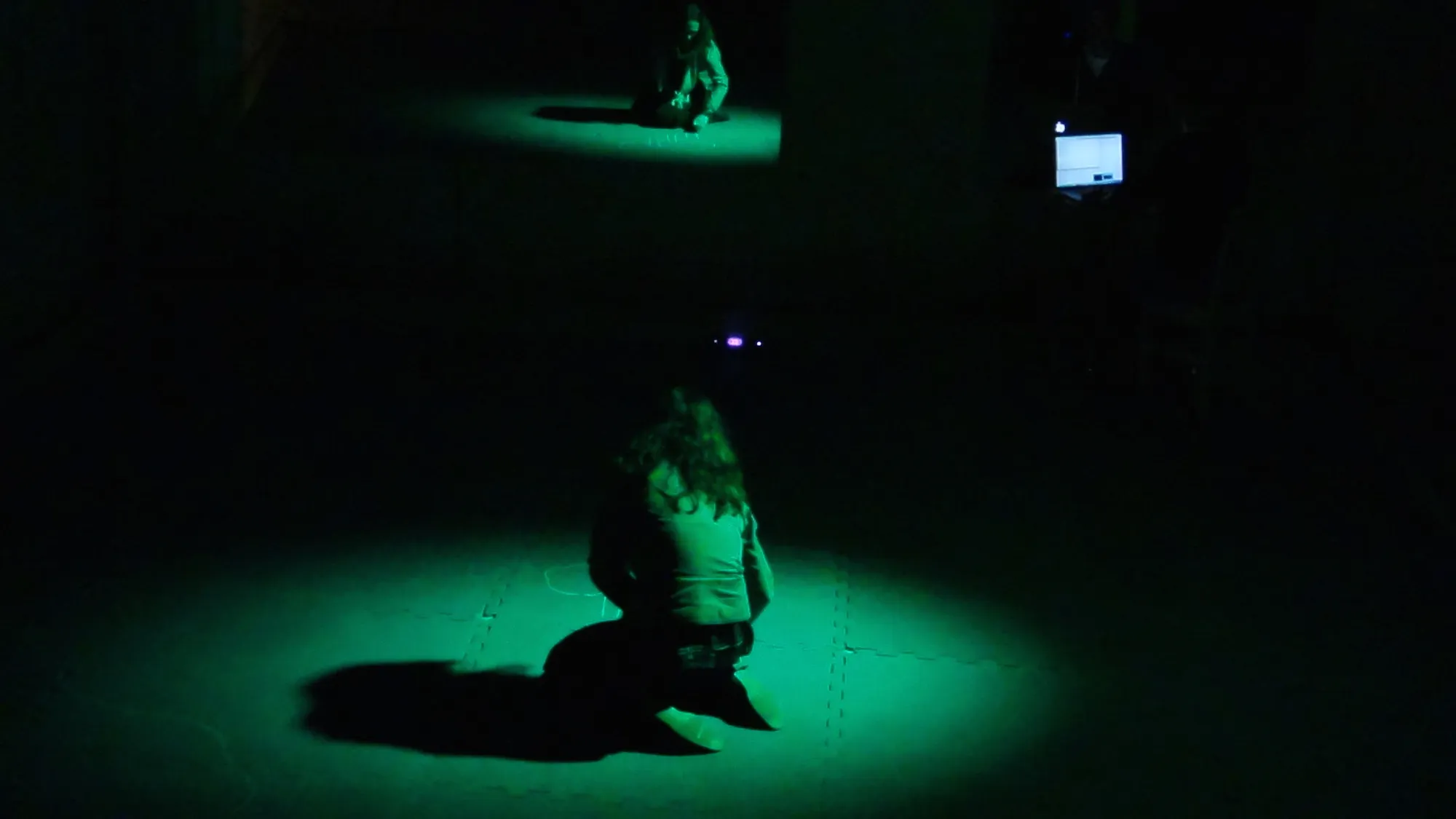 An audience member draws on the floor during the public sharing of the week's work.