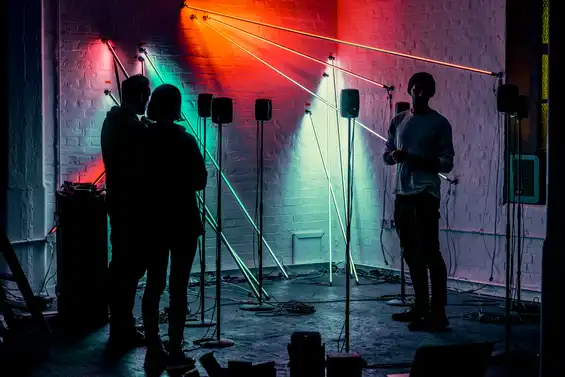 Tim Murray-Browne with two others installing the interactive light and sound installation Post Truth and Beauty by Tim Murray-Browne and Aphra Shemza. Photo by Suzi Corker.